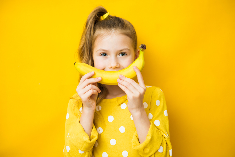 child eating banana