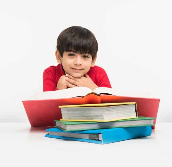 cute-little-indian-asian-boy-holding-reading-book-study-table-white-floor-isolated-white-background
